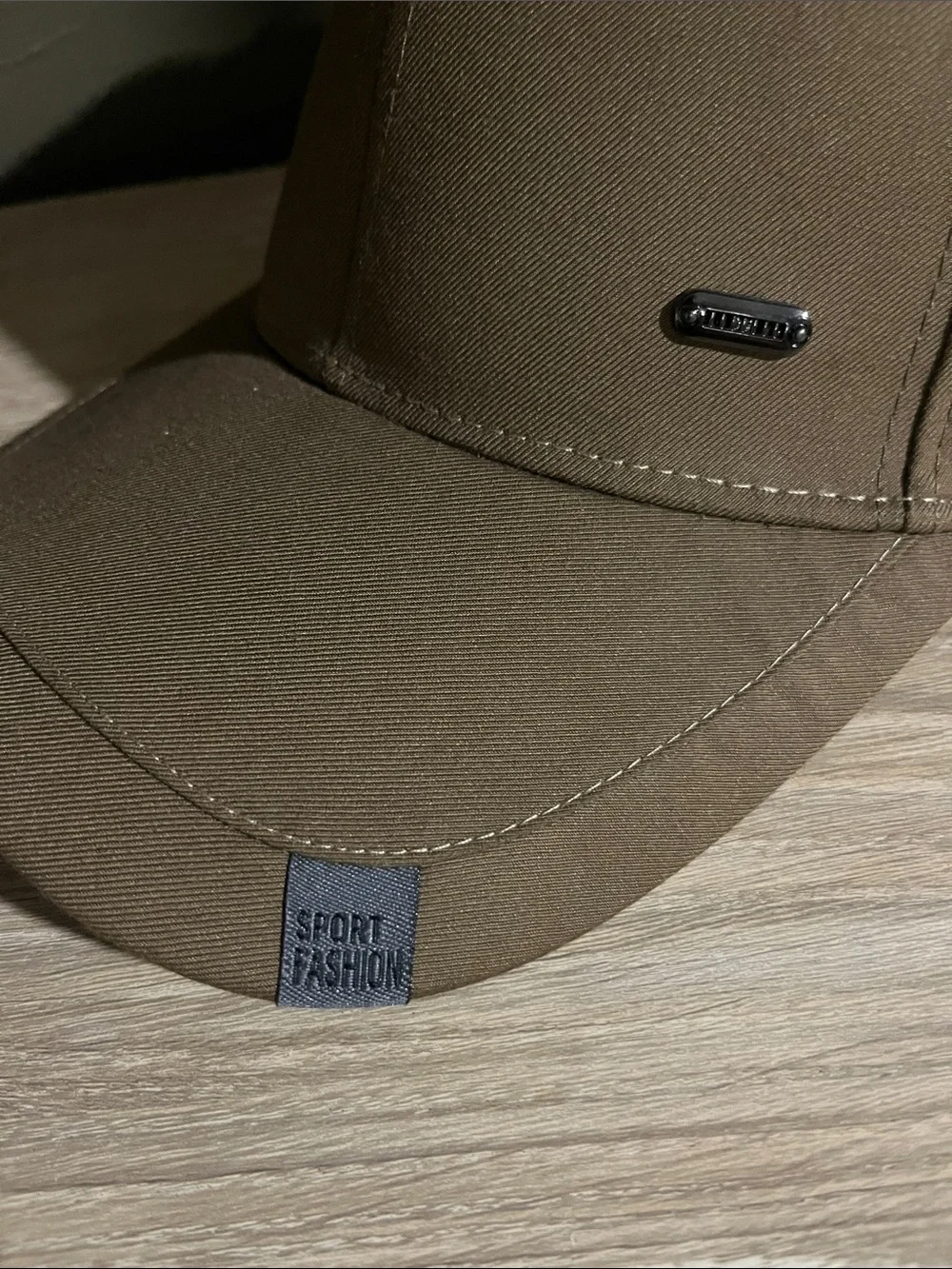Brown Baseball Cap With Small Logo on Brim That Says “Sport Fashion”